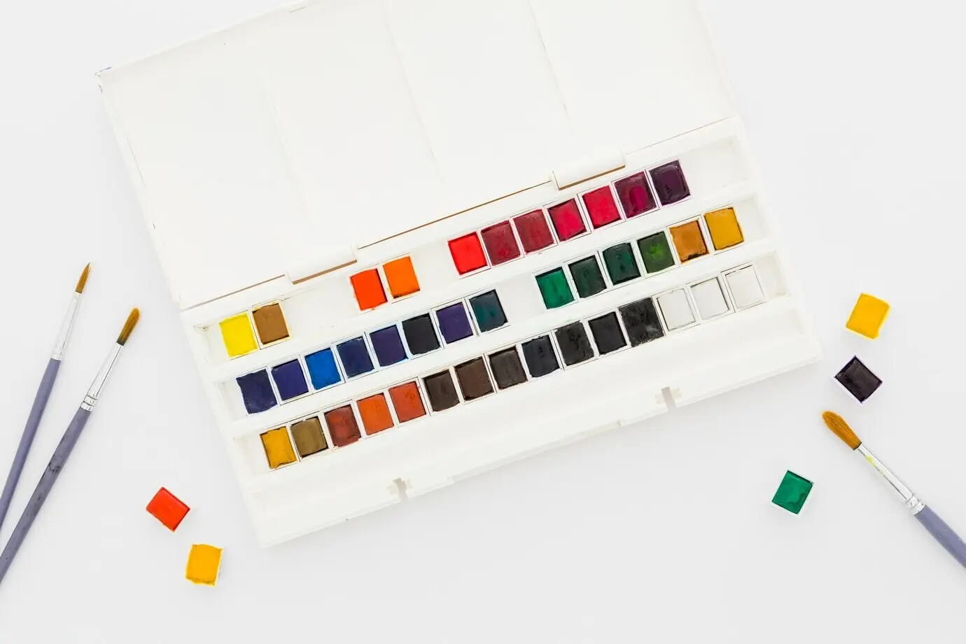 Draufsicht auf Aquarellfarben und Pinsel